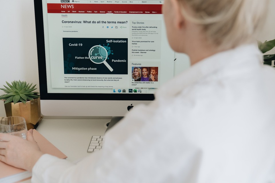 A business person reading a BBC News article on a computer