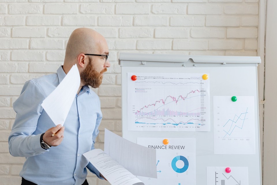 Man presenting YouTube charts and graphs on a whiteboard.